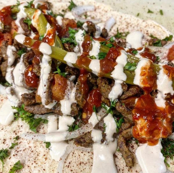 Photo of beef pita wrap with sauces drizzled